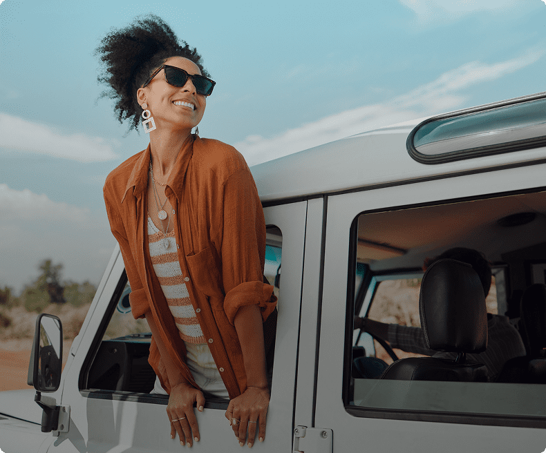 A woman leaning on the side of a van.