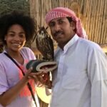 Man and woman holding a falcon together.